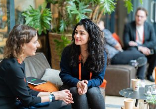 Image of the ONE conference event, two women talking with each other.